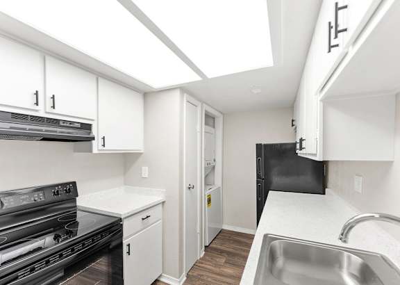 a kitchen with a sink stove and oven