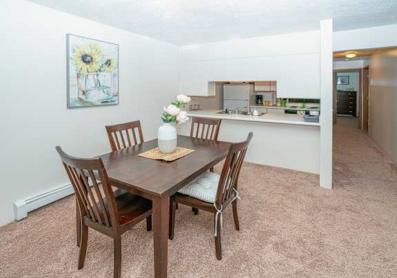 a dining room and kitchen with a table and chairs