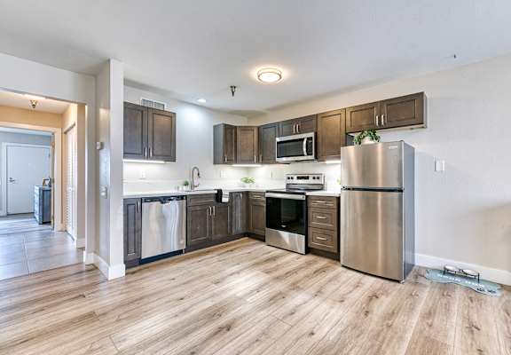 A kitchen with wooden floors and stainless steel appliances.