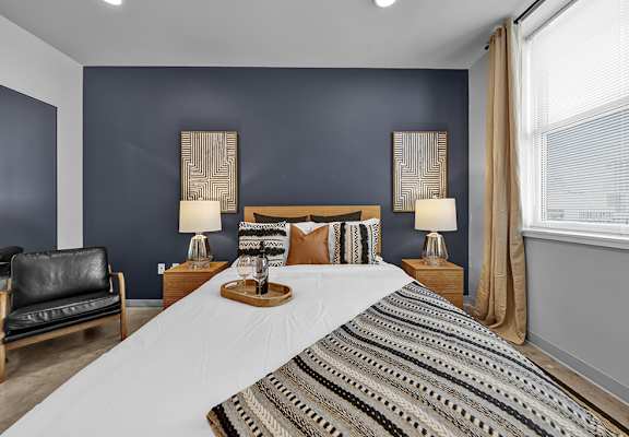 a bedroom with a bed and two windows