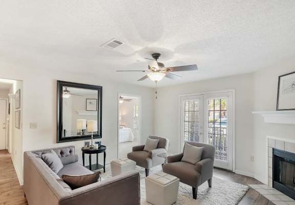 a living room with a couch and a chair in front of a fireplace