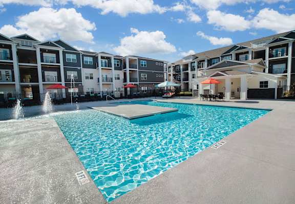 A large swimming pool in front of apartment buildings.