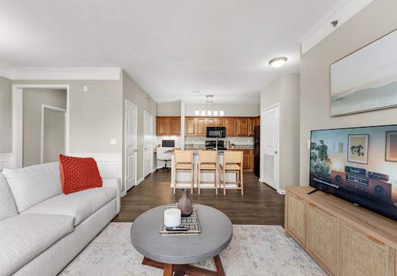 A living room with a grey couch and a television on a wooden stand.