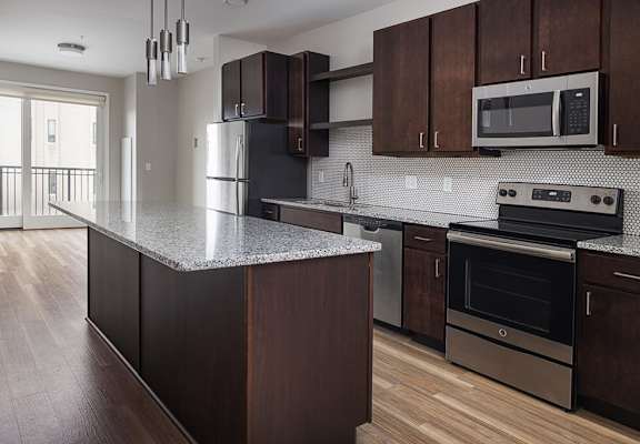 A kitchen with a granite counter top and stainless steel appliances at RoCo Apartments in Fargo, ND 58102