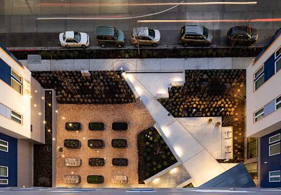 an aerial view of a building with cars parked on the street at The Aries at Bitter Lake Apartments, Seattle