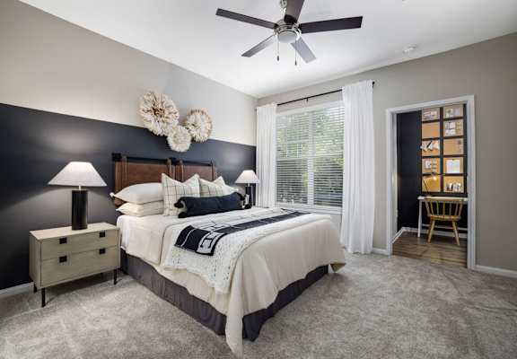 a bedroom with a bed and a ceiling fan