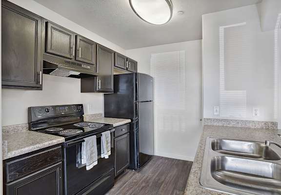 A kitchen with a black refrigerator and stove.