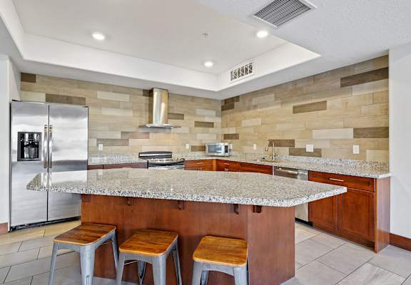 a kitchen with a granite counter top and a stainless steel refrigerator