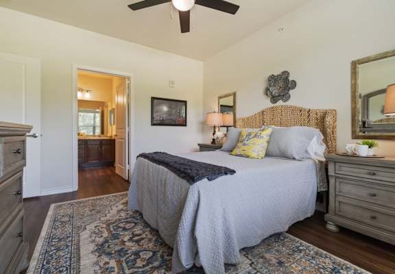 Spacious bedroom with dresser and mirror at Auberge of Tyler apartments in Tyler TX.