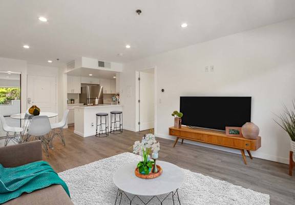 a living room with a television and a kitchen in the background at Masselin Park West, California, 90036