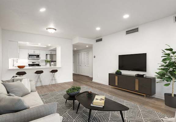 Living room with a view of the kitchen and hardwood flooring