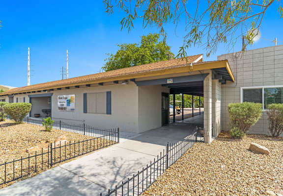 a building with an open door and a tree in the background