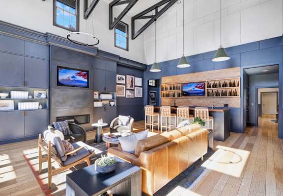 A modern living room with a large sofa and a television on the wall.