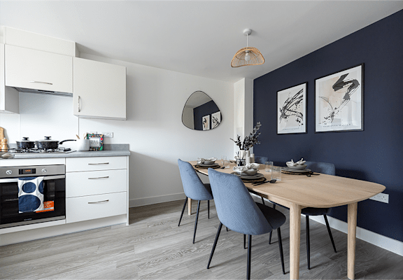 A modern kitchen with a dining table set for two.
