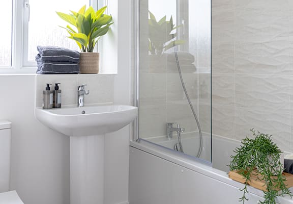 a white bathroom with a sink and a shower