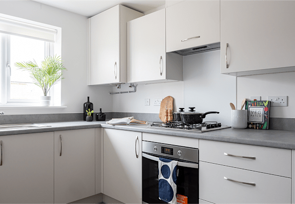 A kitchen with a washing machine on the counter.