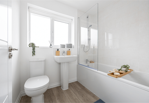 a white ensuite bathroom with a toilet sink and shower