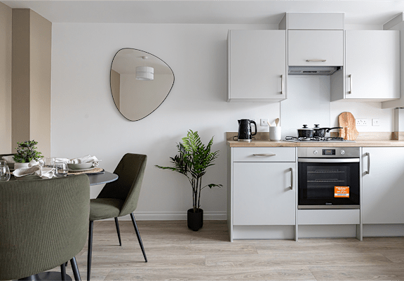 A modern kitchen with a dining table set for two.