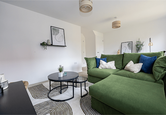 A living room with a green couch and a black table.