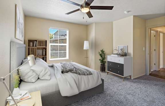 A bedroom with a bed, nightstand, and a ceiling fan. at Bluffs Apartments, Utah, 84065