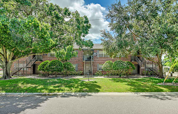 A house with a driveway and trees in front. at Green Oaks Apartments, Apartments, Tampa, FL