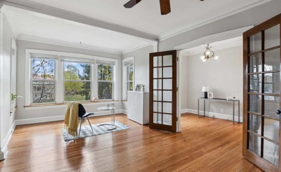 the living room has a hardwood floor and a large window at The Bryant at Oak Park I & II, Oak Park