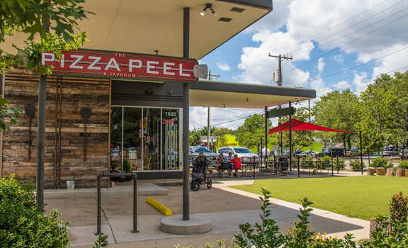a gas station with a pizza peel sign on the front of it