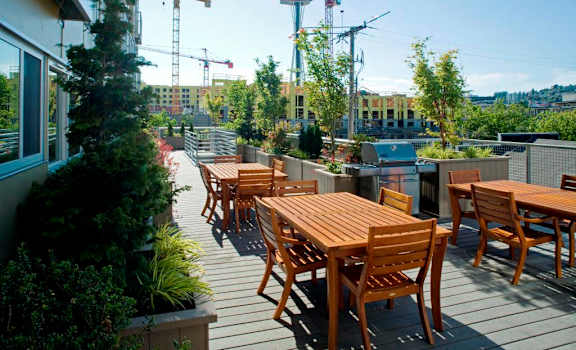 a roof top patio with wooden tables and chairs