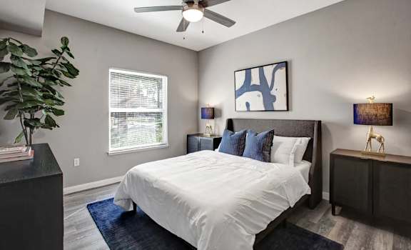 A bedroom with a large bed and a ceiling fan.