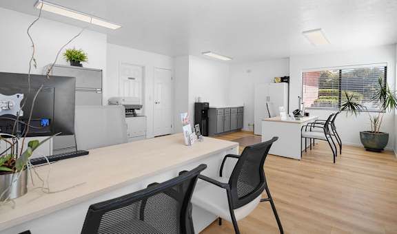 a living room and kitchen with a desk and chairs