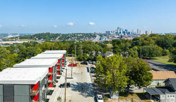 A view of a city skyline from a distance with a parking lot in the foreground.