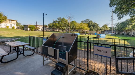 a picnic area with a grill and picnic table at the whispering winds apartments in pearland, at Sunset Ridge, Texas, 78209