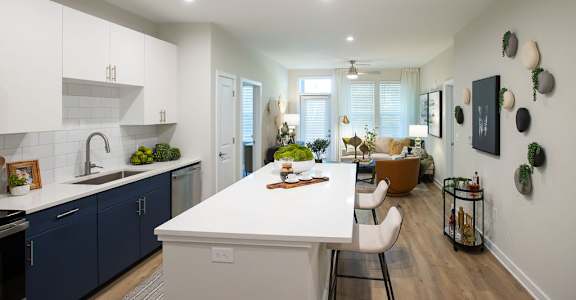 a kitchen and living room with a white counter top