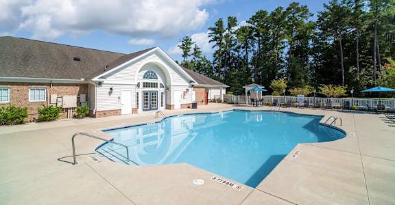 A swimming pool in front of a house.