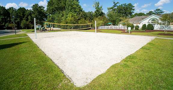 A tennis court surrounded by a green lawn.