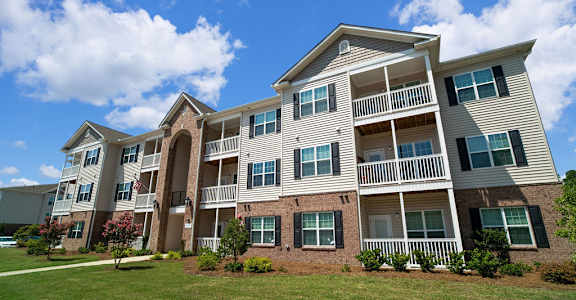 A large apartment building with multiple balconies and windows.