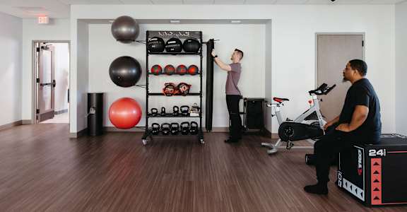 two people in a fitness room with weights and exercise equipment