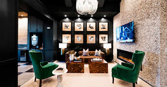 A living room with a green chair and a fireplace at Evolve St. James Apartment Homes Apartments, Southport, NC, 28461