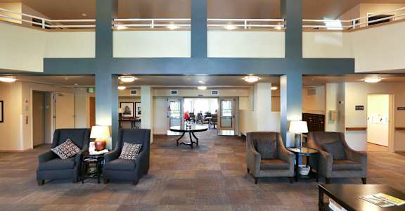 A large room with a carpeted floor and a balcony with a railing at VINTAGE AT BELLINGHAM, Bellingham, WA