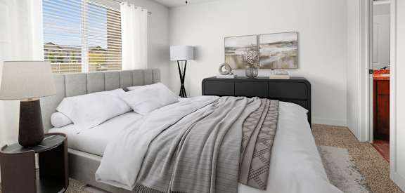 A bedroom with a bed, a ceiling fan, and a painting on the wall.