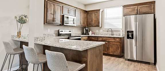A kitchen with a granite countertop and a refrigerator.