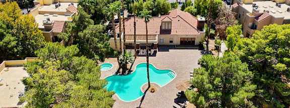 A house with a pool surrounded by trees.