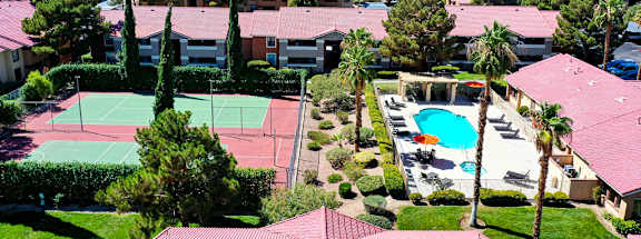 A view of a tennis court and a swimming pool from a high angle.