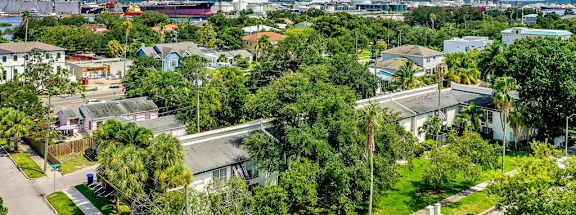 A view of a residential area with houses, trees, and cars.