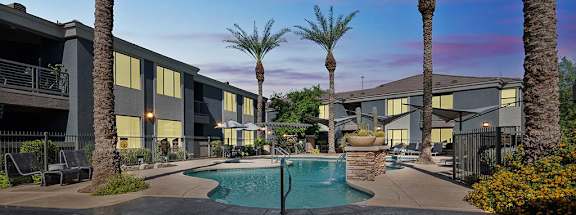 a swimming pool with palm trees in front of a building at Element Deer Valley in Phoenix, Arizona