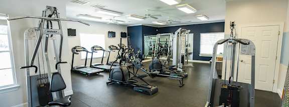 A gym with a variety of equipment including a leg press machine.