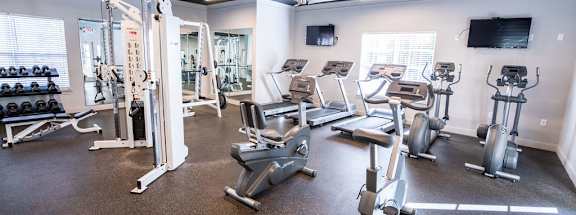 A spacious gym with a variety of equipment including treadmills, weights, and exercise machines.