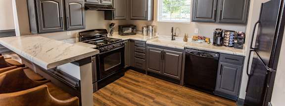A kitchen with black cabinets and a white counter top.