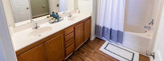 A bathroom with a white sink and a white tub.