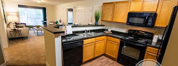 A kitchen with wooden cabinets and black appliances.